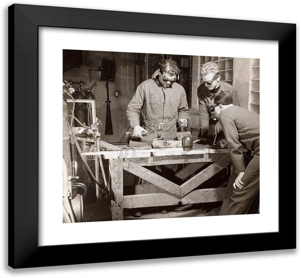 Three Men Wearing Goggles Weld a Piece of Metal on a Table 22x20 Black Modern Wood Framed Art Print Poster by Eagle, Arnold