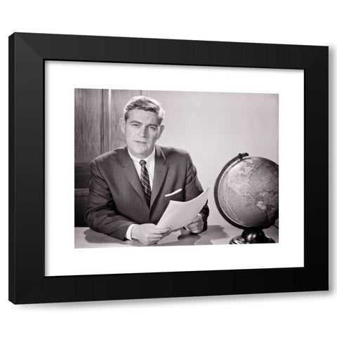 1960's Image Collection by ClassicStock - Black Modern Wood Framed Art Print Titled: 1960s MAN READING FROM DOCUMENT SEATED AT DESK WITH WORLD GLOBE LOOKING AT CAMERA TEACHER NEWSMAN ANNOUNCER BROADCASTER SPEAKER - s11506 HAR001 HARS JOURNA