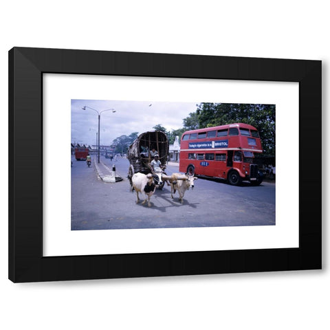 1960's Image Collection by James Davis Photography - Black Modern Wood Framed Art Print Titled: Old ox drawn cart and bright red ex London bus with Bristol cigarette advert on the side in mid 1960s in Colombo Sri Lanka