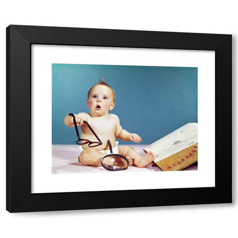 1960's Image Collection by ClassicStock - Black Modern Wood Framed Art Print Titled: 1960s BABY HOLDING EYEGLASSES WITH OPEN DICTIONARY AND MAGNIFYING GLASS RESEARCH