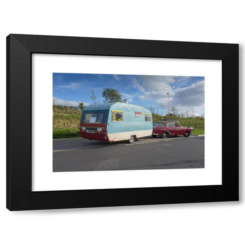 1960's Image Collection by Peter Lopeman - Black Modern Wood Framed Art Print Titled: Tradition caravan trailer from the 1960s being towed by an old car from the same period, parked at a motorway services