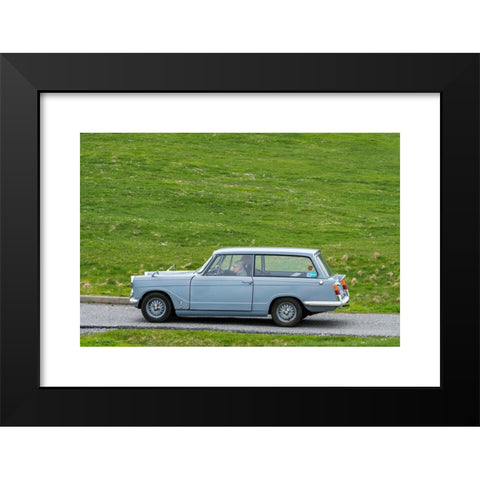 1960's Image Collection by Arterra Picture Library - Black Modern Wood Framed Art Print Titled: Elderly couple driving 1967 classic car Triumph Herald 1200 Estate along country road through meadow