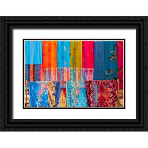 Laos- Luang Prabang. Colorful textiles- possibly scarves- for sale. Black Ornate Wood Framed Art Print with Double Matting by Haseltine, Tom