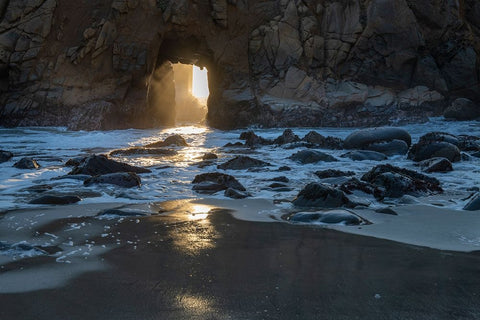 Sun shines through a tunnel in a sea cliff in the Big Sur area. Black Ornate Wood Framed Art Print with Double Matting by Sederquist, Betty