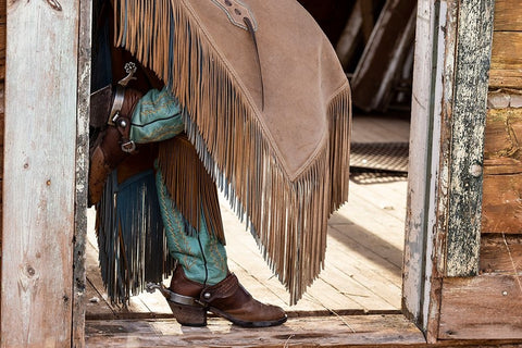USA- Shell- Wyoming. Hideout Ranch cowgirl standing in doorway with cowboy boots and chaps.  Black Ornate Wood Framed Art Print with Double Matting by Gulin, Darrell