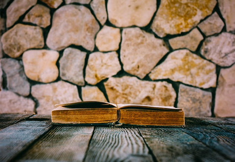 Old Open Book On Old Wooden Table On A Background Of Stone Walls Black Ornate Wood Framed Art Print with Double Matting by Solovie, Andre