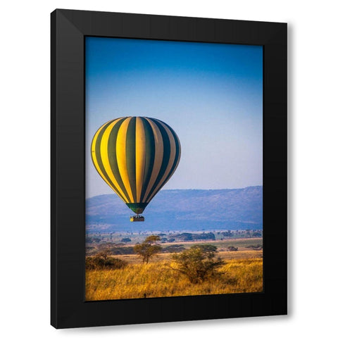A hot-air balloon slowly traverses over the Serengeti plain Black Modern Wood Framed Art Print by Richardson, Larry