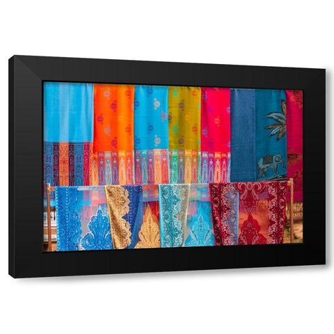 Laos- Luang Prabang. Colorful textiles- possibly scarves- for sale. Black Modern Wood Framed Art Print by Haseltine, Tom