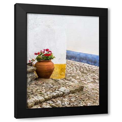 Portugal-Obidos-Red geranium growing in a terra cotta pot next to the entrance of a home in the his Black Modern Wood Framed Art Print by Eggers, Julie