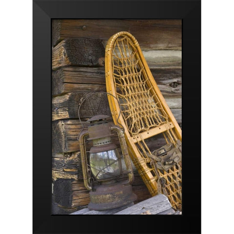 MT, A lantern and snowshoe outside a log cabin Black Modern Wood Framed Art Print by Paulson, Don