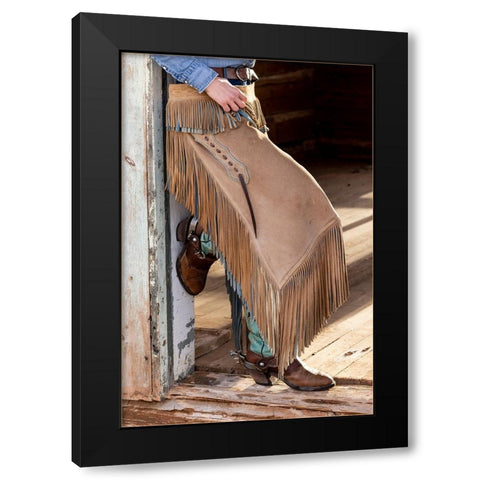 USA- Shell- Wyoming. Hideout Ranch cowgirl standing in doorway with cowboy boots and chaps.  Black Modern Wood Framed Art Print with Double Matting by Gulin, Darrell