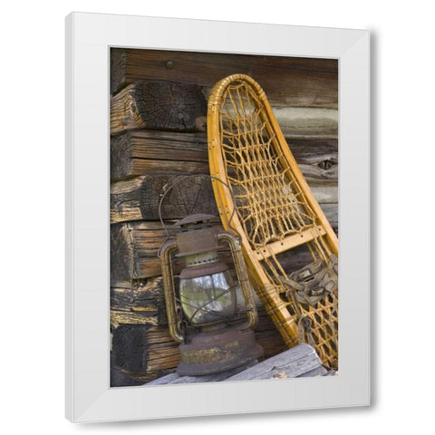 MT, A lantern and snowshoe outside a log cabin White Modern Wood Framed Art Print by Paulson, Don